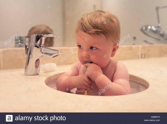baby-boy-sitting-in-a-sink-brushing-his-teeth-X2MMTH.jpg